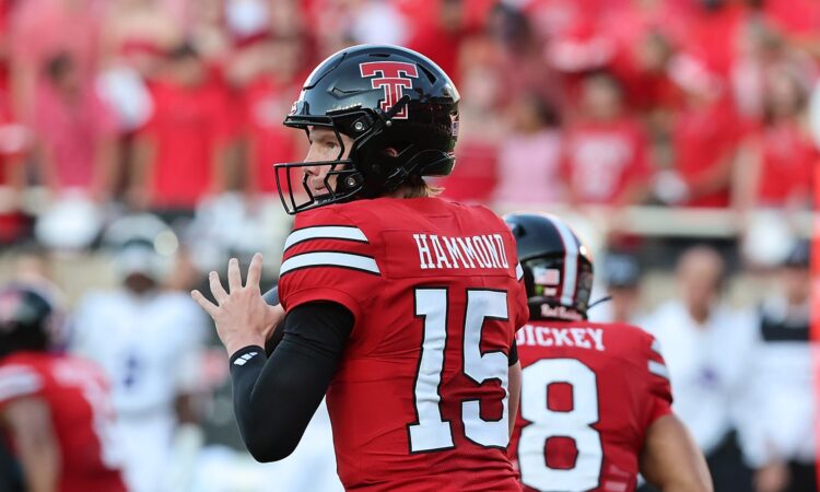 Texas Tech quarterback Will Hammond, No. 15, cocks the ball to pass with a teammate in front of him.