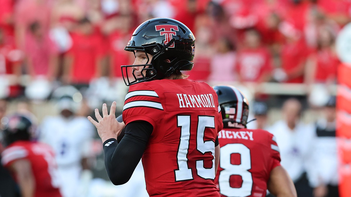 Texas Tech quarterback Will Hammond, No. 15, cocks the ball to pass with a teammate in front of him.