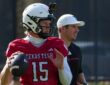 Texas Tech quarterback Will Hammond winds up to throw at practice as offensive coordinator Mack Leftwich watches.