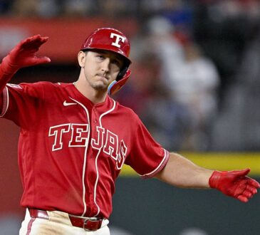 Texas Rangers left fielder Wyatt Langford celebrates with his arms out after hitting a double.