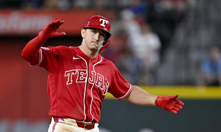 Texas Rangers left fielder Wyatt Langford celebrates with his arms out after hitting a double.