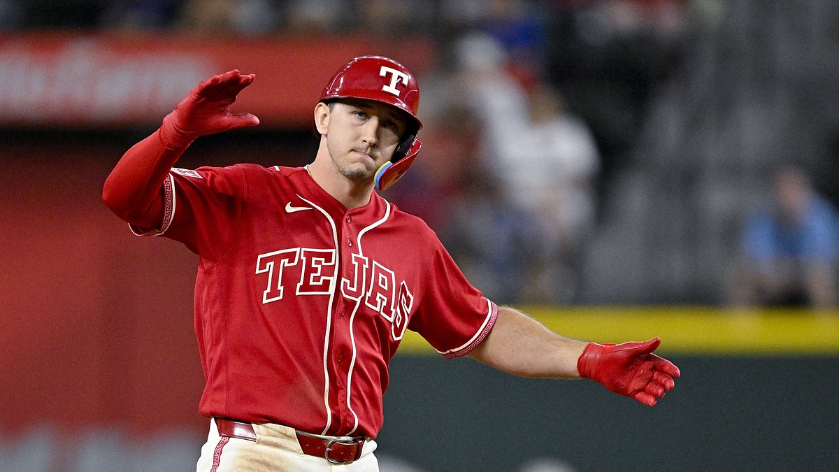 Texas Rangers left fielder Wyatt Langford celebrates with his arms out after hitting a double.