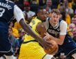 Mavericks forward Cooper Flagg battles Pacers guard Aaron Nesmith for position as a Mavericks teammate dribbles in the foreground.