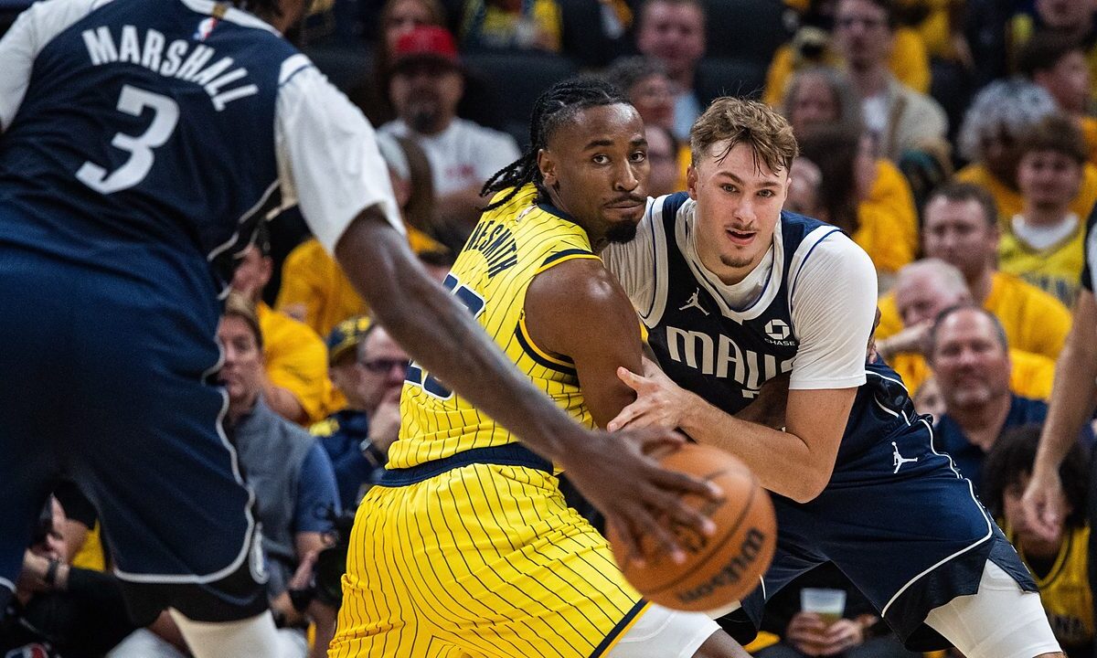 Mavericks forward Cooper Flagg battles Pacers guard Aaron Nesmith for position as a Mavericks teammate dribbles in the foreground.