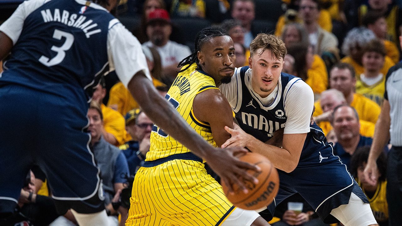 Mavericks forward Cooper Flagg battles Pacers guard Aaron Nesmith for position as a Mavericks teammate dribbles in the foreground.