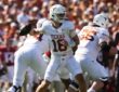Texas quarterback Arch Manning cocks the ball back to throw as his offensive linemen pass block.