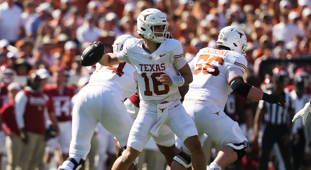 Texas quarterback Arch Manning cocks the ball back to throw as his offensive linemen pass block.