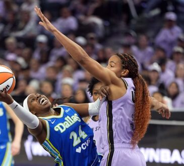 Dallas Wings guard Arike Ogunbowale leans back on a shot as Golden State Valkyries center Kiah Stokes contests.