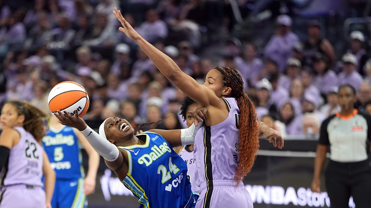 Dallas Wings guard Arike Ogunbowale leans back on a shot as Golden State Valkyries center Kiah Stokes contests.