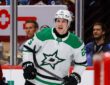 Dallas Stars right wing Arttu Hyry shouts in celebration in front of the glass, holding his stick low.
