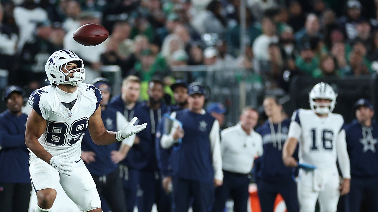 Dallas Cowboys tight end Brevyn Spann-Ford tracks a pass with his eyes as the ball drops toward his hands near the sideline.