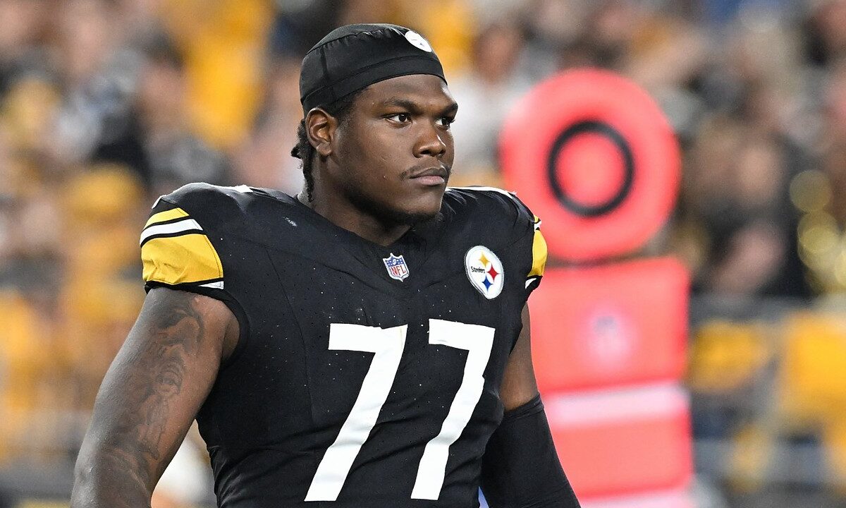 Pittsburgh Steelers offensive tackle Broderick Jones looks on from the field in a black No. 77 jersey and skullcap.