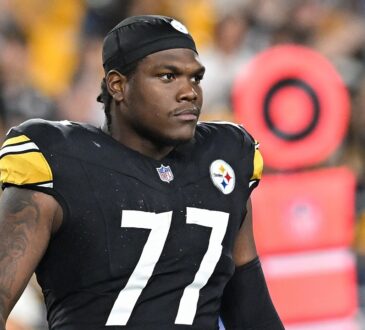 Pittsburgh Steelers offensive tackle Broderick Jones looks on from the field in a black No. 77 jersey and skullcap.