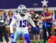 Dallas Cowboys safety Caleb Downs, wearing No. 13 in white, backpedals into coverage on the field at a home game.