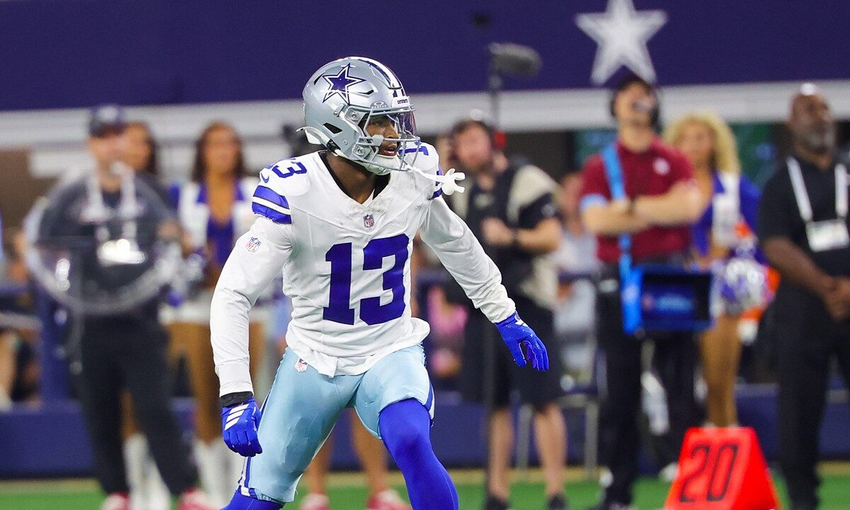 Dallas Cowboys safety Caleb Downs, wearing No. 13 in white, backpedals into coverage on the field at a home game.