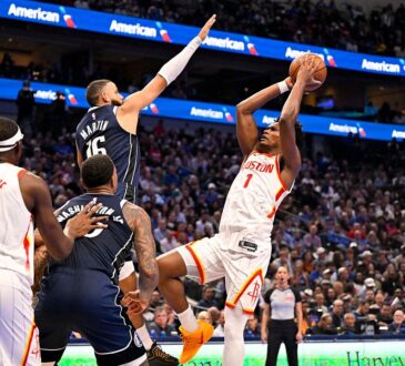 Mavericks forward Caleb Martin leaps to contest a shot by Rockets guard Amen Thompson.