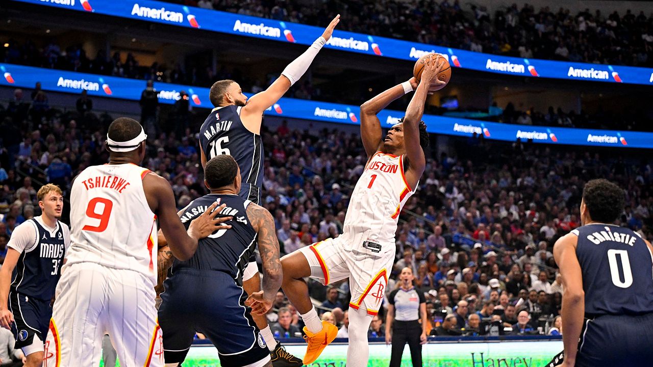 Mavericks forward Caleb Martin leaps to contest a shot by Rockets guard Amen Thompson.