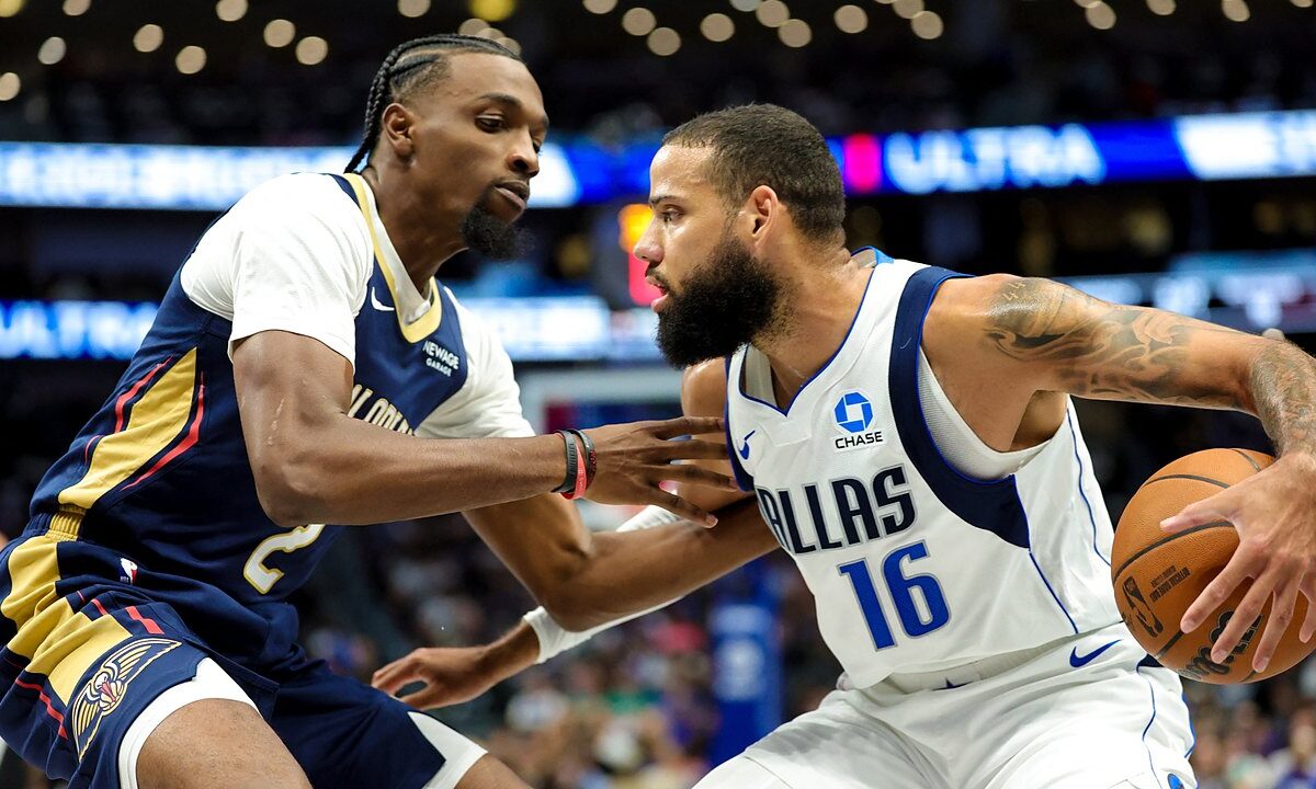Dallas Mavericks forward Caleb Martin protects the ball with his right hand as New Orleans Pelicans forward Herbert Jones guards him.