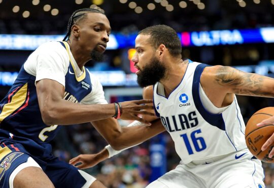 Dallas Mavericks forward Caleb Martin protects the ball with his right hand as New Orleans Pelicans forward Herbert Jones guards him.