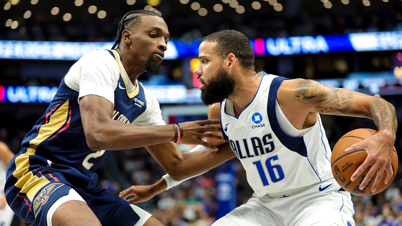 Dallas Mavericks forward Caleb Martin protects the ball with his right hand as New Orleans Pelicans forward Herbert Jones guards him.