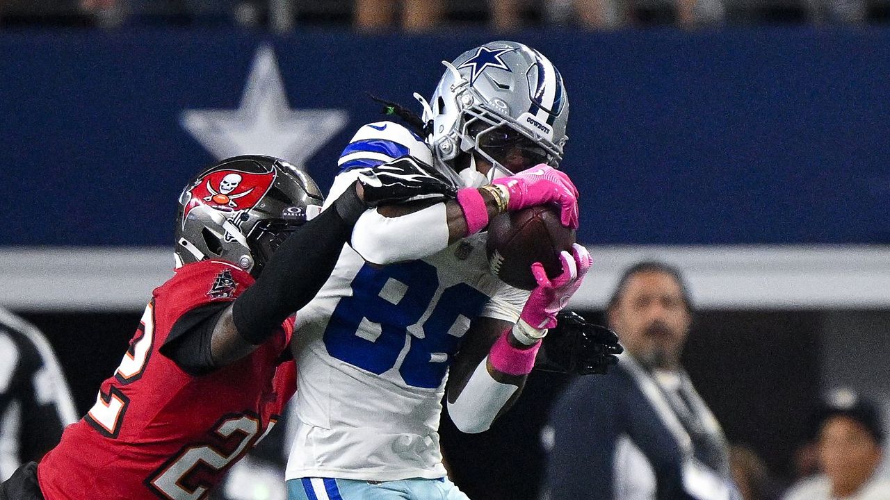 Dallas Cowboys wide receiver CeeDee Lamb secures a catch as Tampa Bay Buccaneers cornerback Keionte Scott reaches over his shoulder.