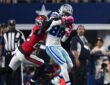 Cowboys wide receiver CeeDee Lamb secures a catch as Buccaneers cornerback Keionte Scott wraps him from behind.