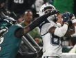 Dallas Cowboys wide receiver CeeDee Lamb hauls in a pass against his chest as an Eagles cornerback reaches across his face mask.
