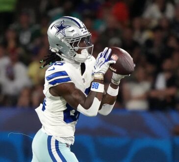 Dallas Cowboys wide receiver CeeDee Lamb catches the ball with both hands while running in stride.