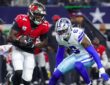 Buccaneers wide receiver Chris Godwin Jr. runs with the ball as Cowboys linebacker Donovan Ezeiruaku closes in.