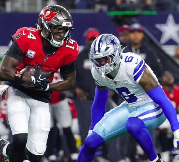 Buccaneers wide receiver Chris Godwin Jr. runs with the ball as Cowboys linebacker Donovan Ezeiruaku closes in.