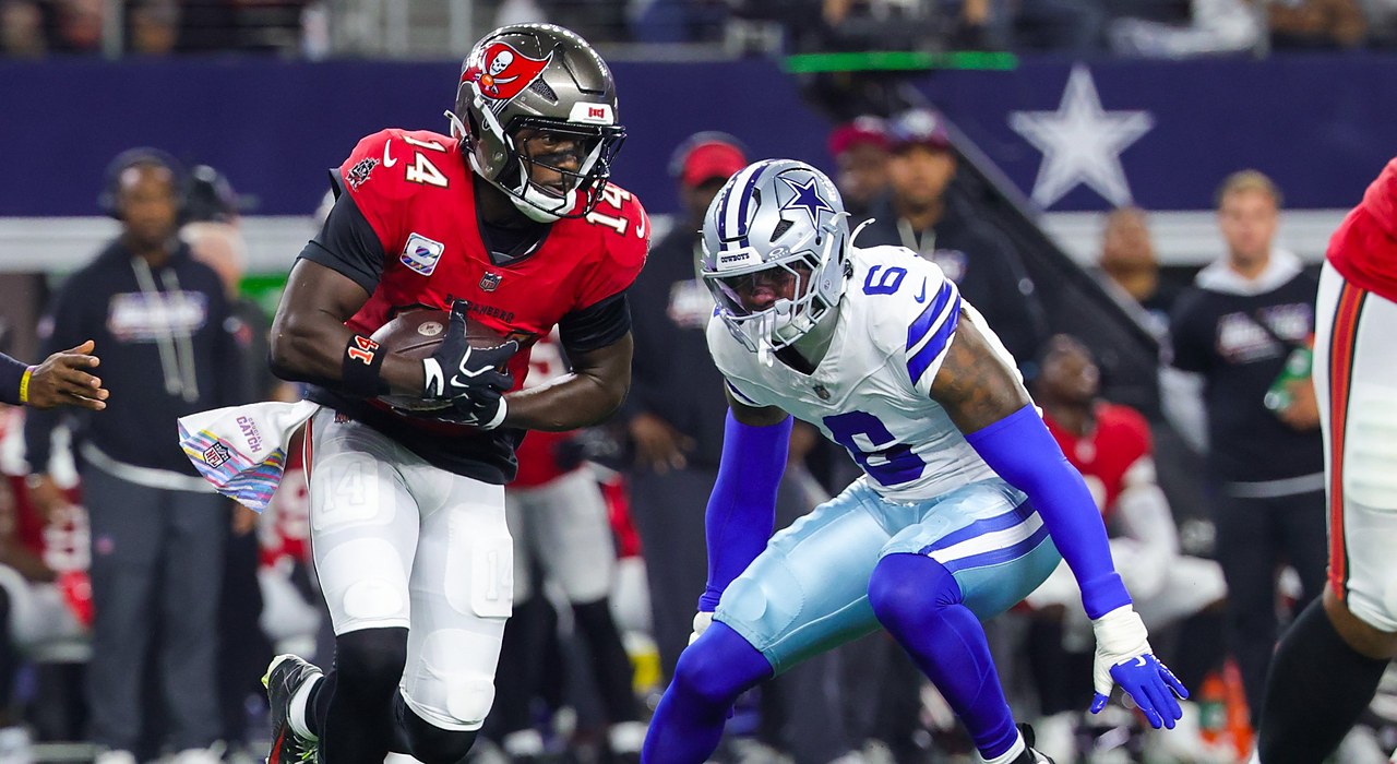 Buccaneers wide receiver Chris Godwin Jr. runs with the ball as Cowboys linebacker Donovan Ezeiruaku closes in.