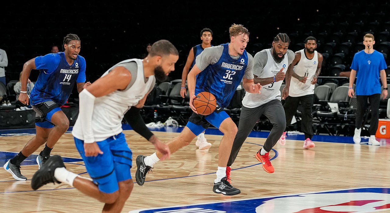 Mavericks forward Cooper Flagg dribbles up the court during a full-team scrimmage as teammates run alongside him.