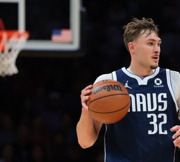 Dallas Mavericks forward Cooper Flagg dribbles the ball up the court with a basket blurred in the background.