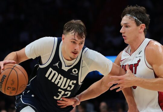 Dallas Mavericks forward Cooper Flagg drives with the ball in his right hand as Miami Heat guard Pelle Larsson defends.