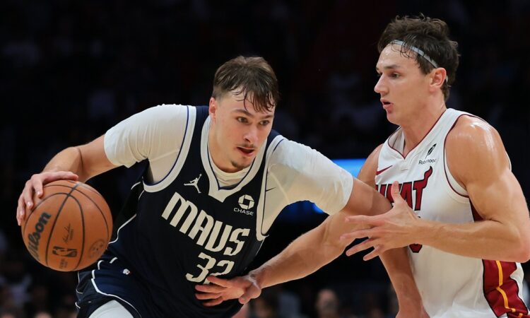 Dallas Mavericks forward Cooper Flagg drives with the ball in his right hand as Miami Heat guard Pelle Larsson defends.