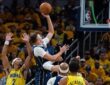 Dallas Mavericks forward Cooper Flagg rises for a one-handed shot as Indiana Pacers guard Andrew Nembhard contests with both hands up.
