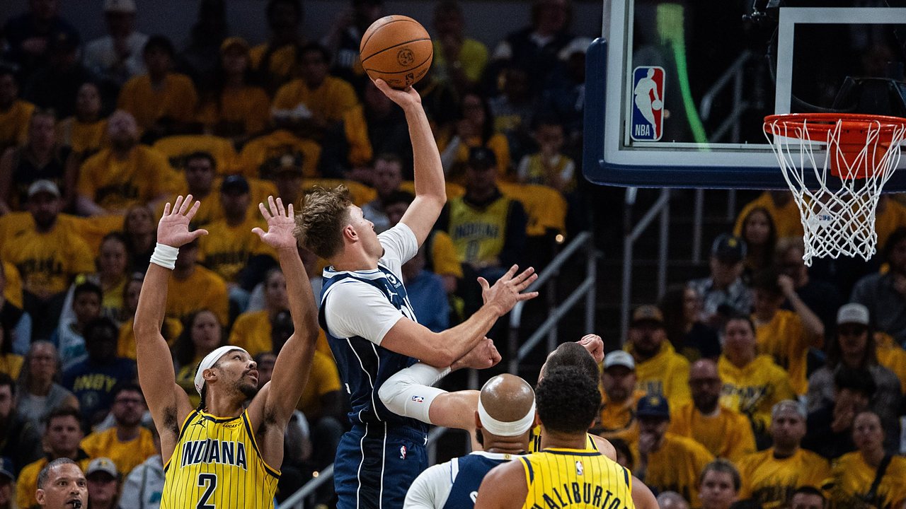 Dallas Mavericks forward Cooper Flagg rises for a one-handed shot as Indiana Pacers guard Andrew Nembhard contests with both hands up.