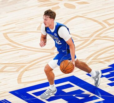 Mavericks forward Cooper Flagg dribbles up the court over Chinese characters painted on the floor.