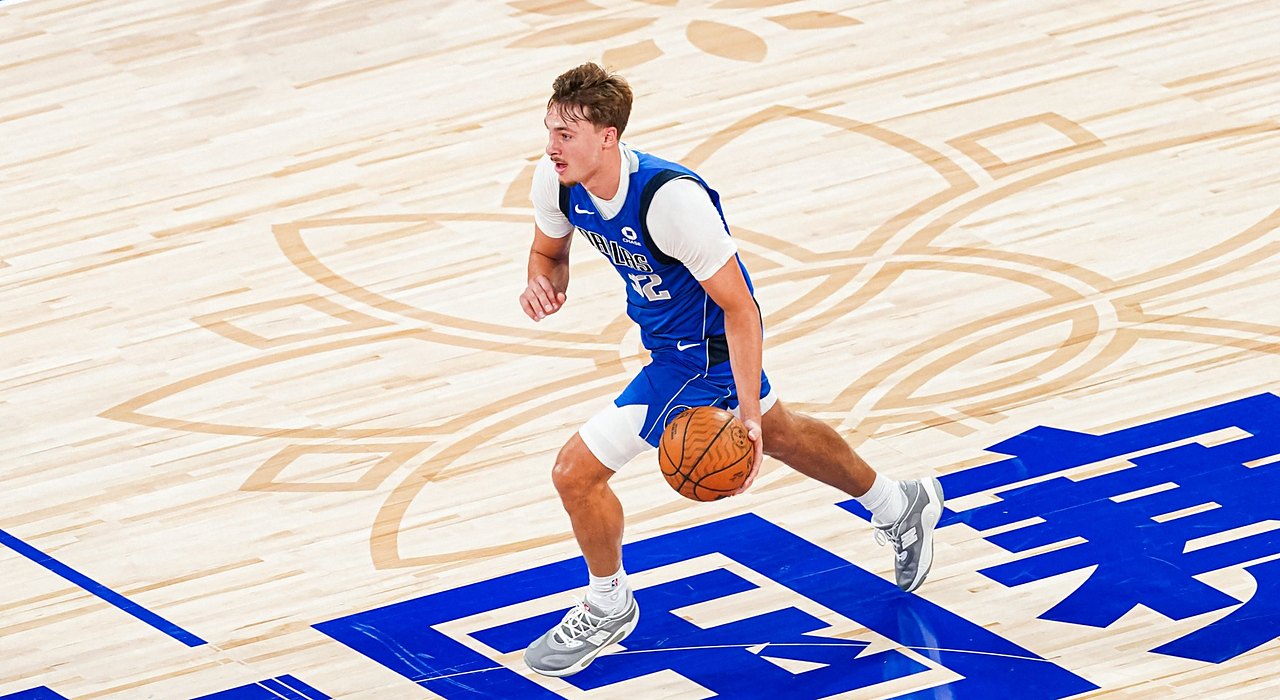 Mavericks forward Cooper Flagg dribbles up the court over Chinese characters painted on the floor.