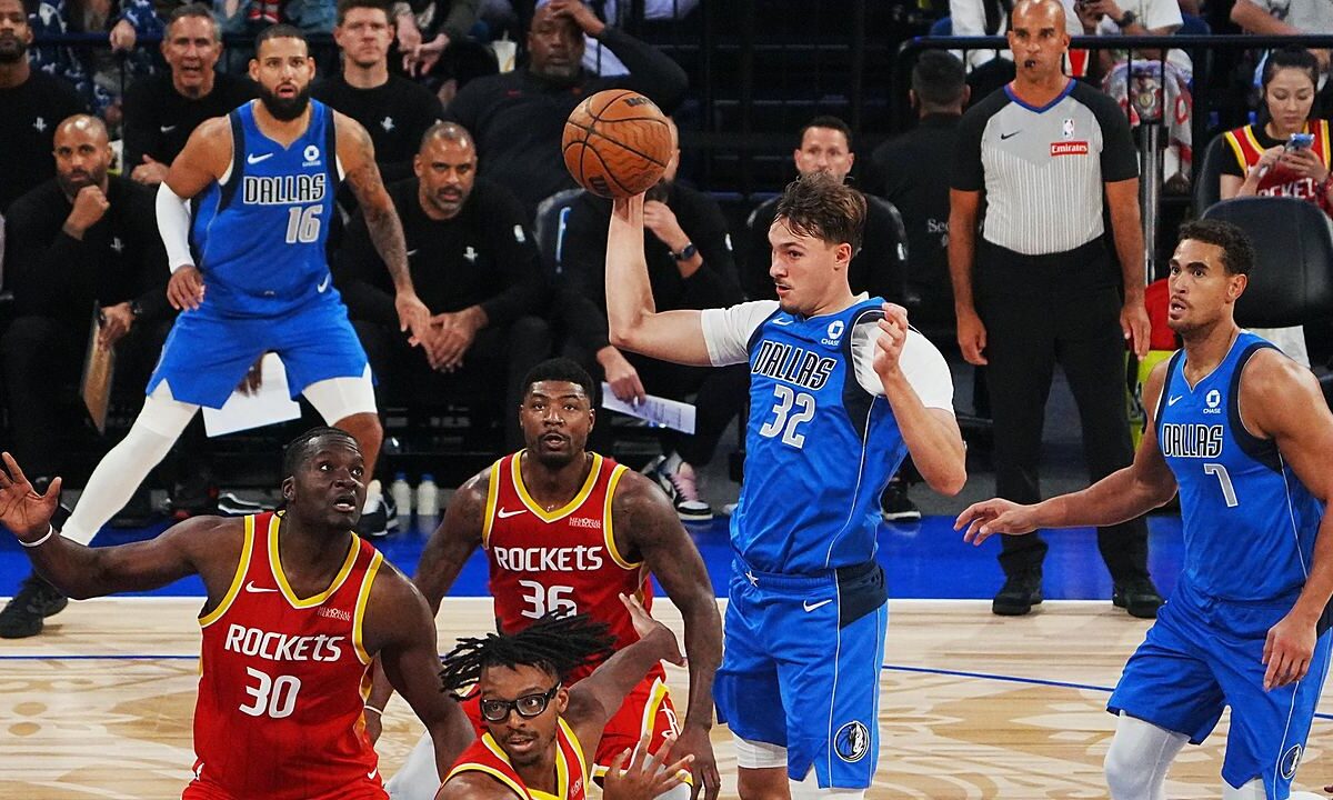 Dallas Mavericks forward Cooper Flagg pulls in a pass with one hand above a group of Houston Rockets players.