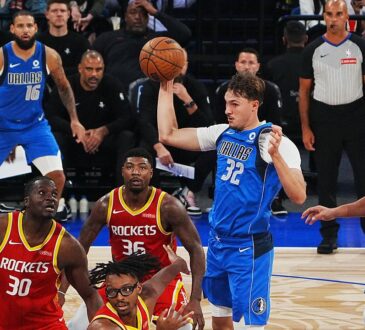 Dallas Mavericks forward Cooper Flagg pulls in a pass with one hand above a group of Houston Rockets players.