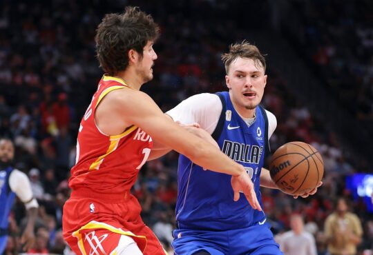 Dallas Mavericks forward Cooper Flagg drives with the ball in his right hand as Houston Rockets guard Reed Sheppard reaches in.