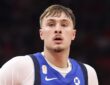 Dallas Mavericks forward Cooper Flagg looks ahead with a small gold patch visible above the Nike swoosh on his blue jersey.