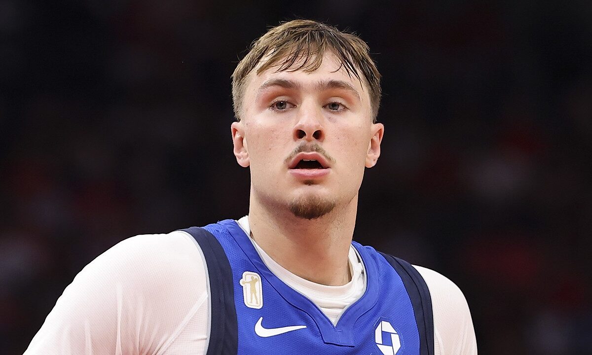 Dallas Mavericks forward Cooper Flagg looks ahead with a small gold patch visible above the Nike swoosh on his blue jersey.