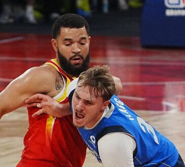 Mavericks forward Cooper Flagg shouts as he drives into Rockets guard Fred VanVleet, who wraps an arm around him.