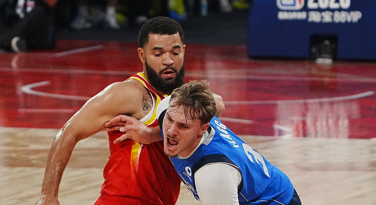 Mavericks forward Cooper Flagg shouts as he drives into Rockets guard Fred VanVleet, who wraps an arm around him.