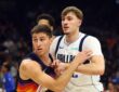 Mavericks forward Cooper Flagg locks arms with Suns guard Collin Gillespie while battling for position.