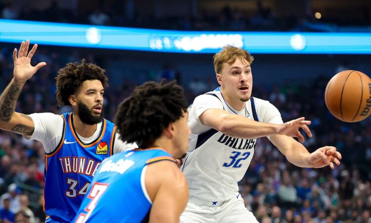 Dallas Mavericks forward Cooper Flagg whips a pass to his left as two Oklahoma City Thunder defenders close in.