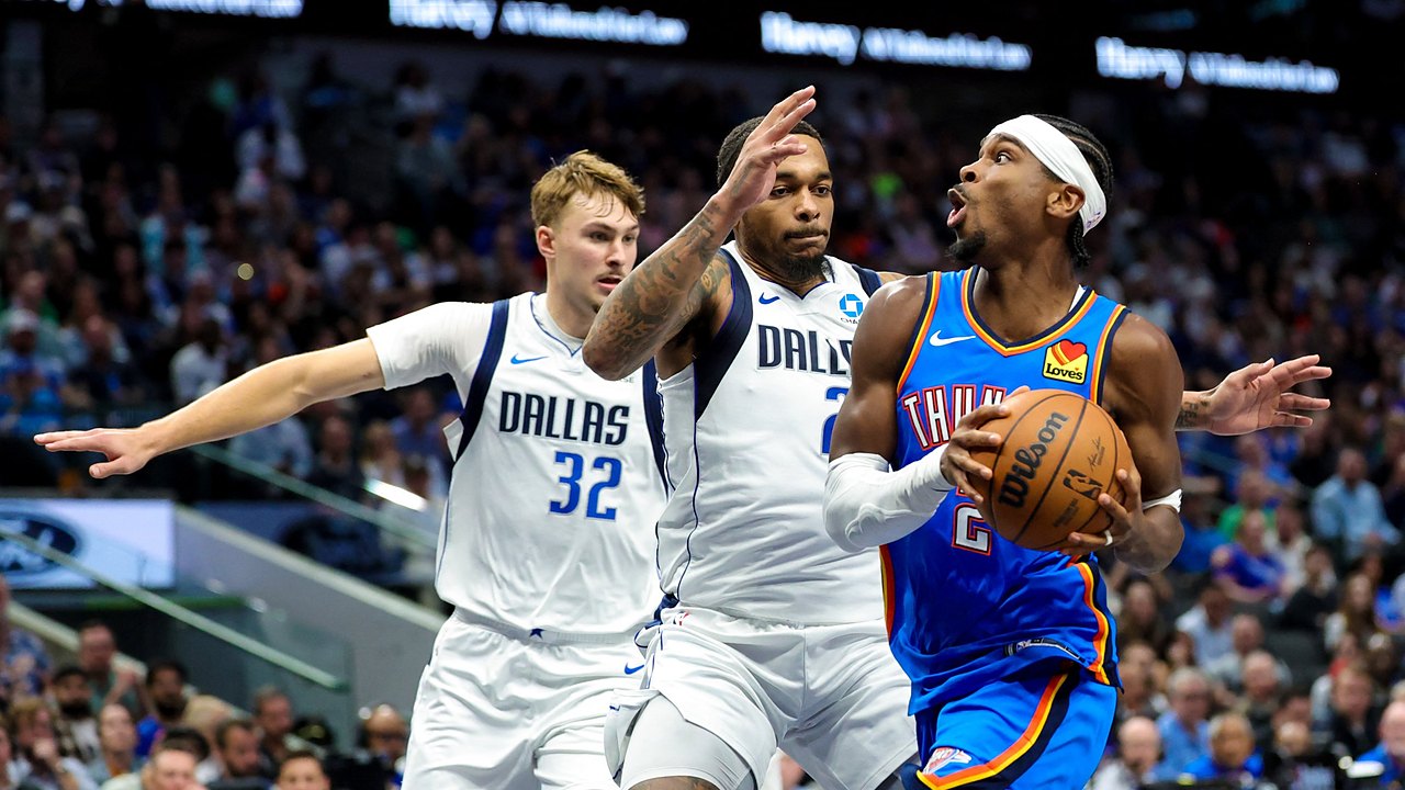 Mavericks forwards Cooper Flagg and P.J. Washington Jr. defend Thunder guard Shai Gilgeous-Alexander on a drive.