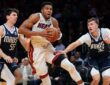 Miami Heat forward Giannis Antetokounmpo drives with the ball between Dallas Mavericks players Sergio de Larrea and Cooper Flagg.